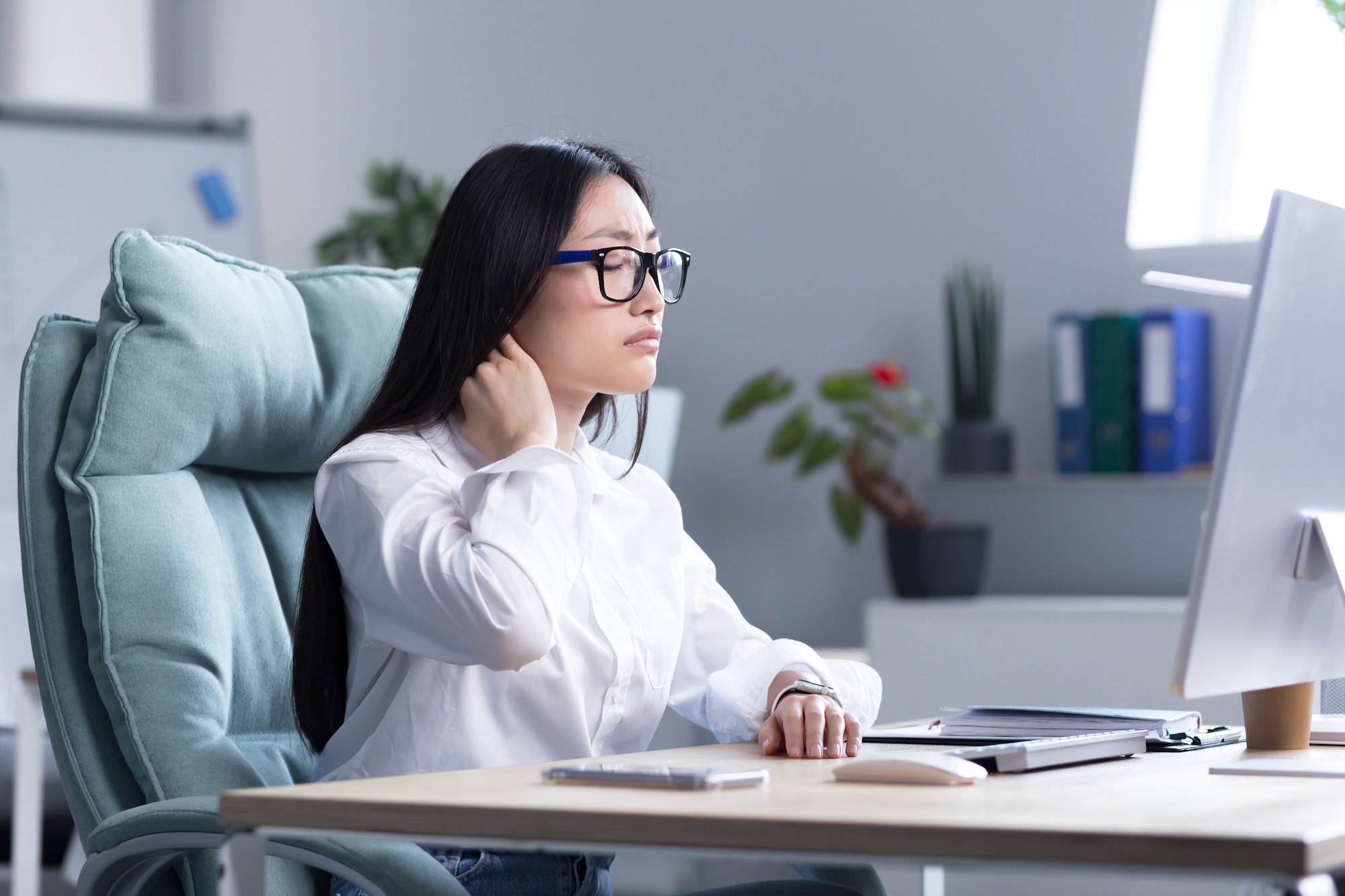 Overtired Asian woman office worker, has severe neck pain